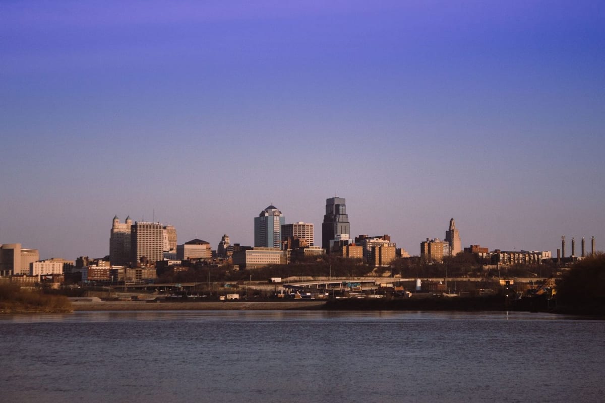 A low skyline across a river at dusk under a purple sky
