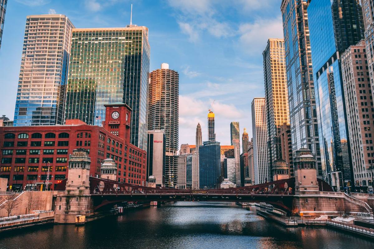 A river running between tall towers, a red brick building and a steel drawbridge on the bank